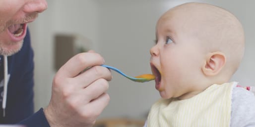 Father spoon feeding baby