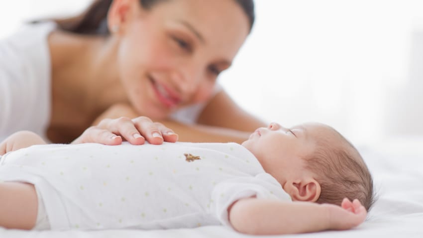 Mother watching over sleeping baby