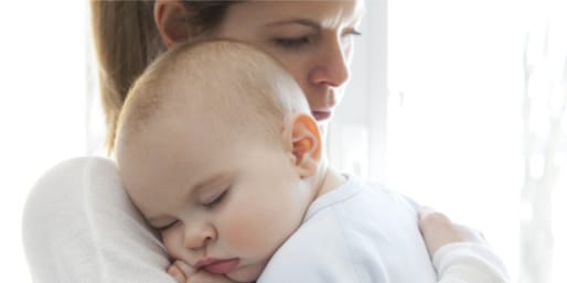 Mother cuddling her baby with infant constipation