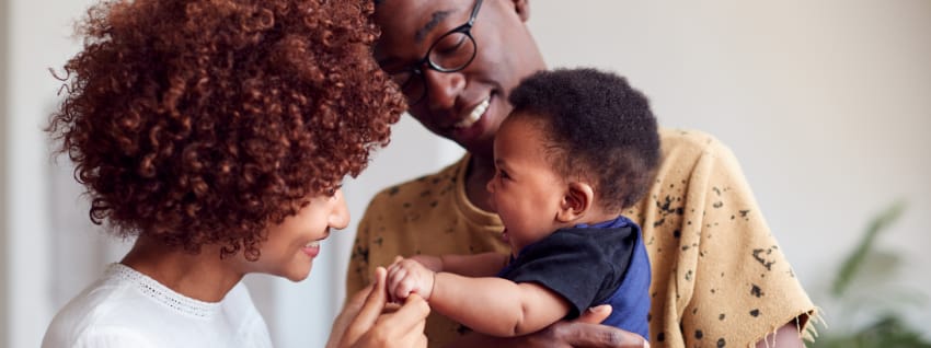 Parents holding and smiling at a baby