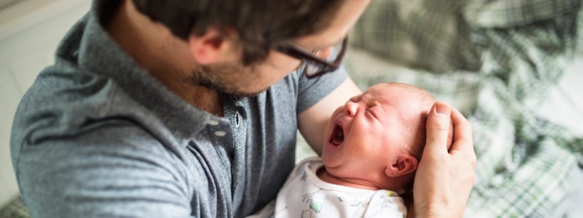 Father comforting crying infant