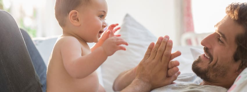 Father and baby playing and smiling