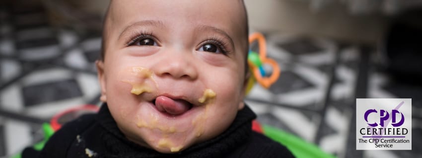 Baby boy eating in high chair