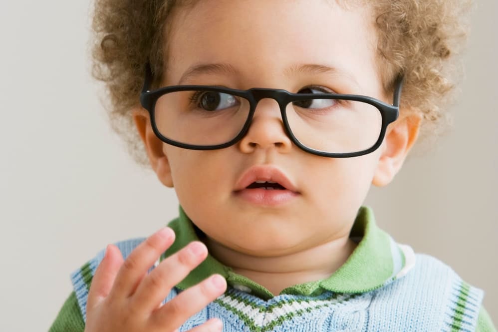 Toddler wearing a pair of glasses looking to his right