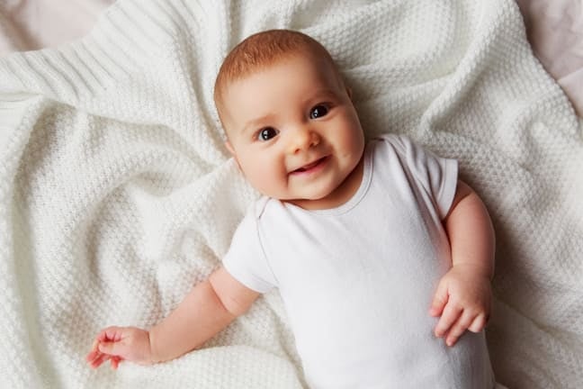 baby lying on back smiling