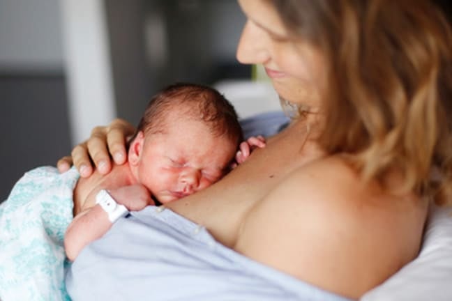 A mother holding her newborn child against her chest