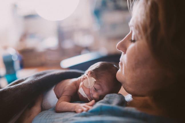 A mother holds her pre-term baby to her